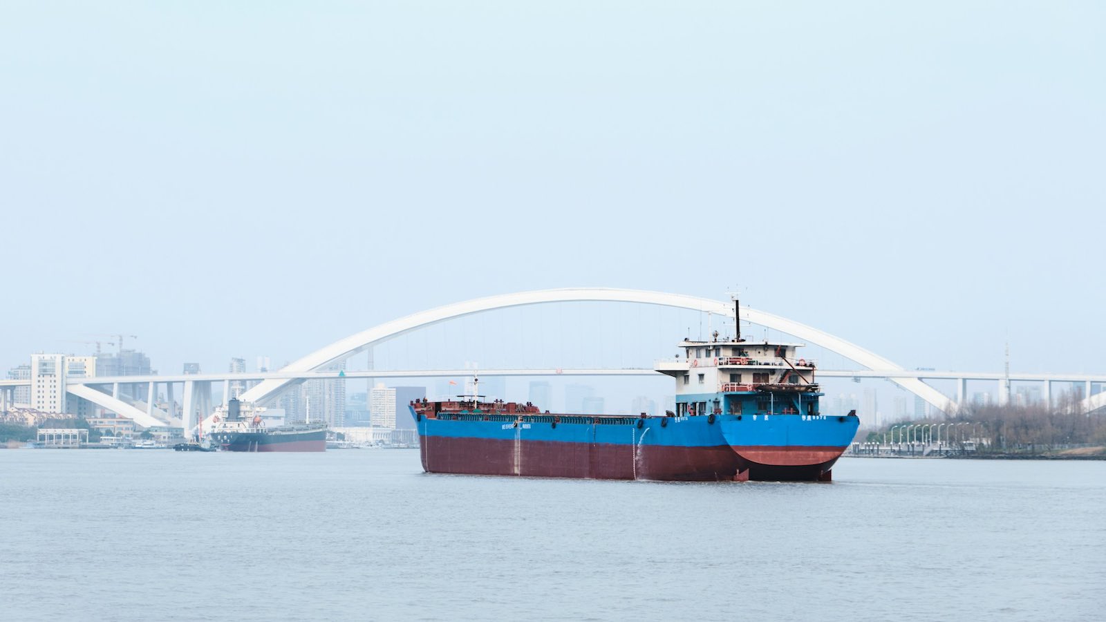 Skipsfarten er avgjørende for kinesisk eksport. Frakteskip i Shanghai. Foto: <a href="https://unsplash.com/@krzhck?utm_content=creditCopyText&utm_medium=referral&utm_source=unsplash">Isaac Chou</a> på <a href="https://unsplash.com/photos/a-large-boat-floating-on-top-of-a-body-of-water-woZs7IumN1Q?utm_content=creditCopyText&utm_medium=referral&utm_source=unsplash">Unsplash</a>   